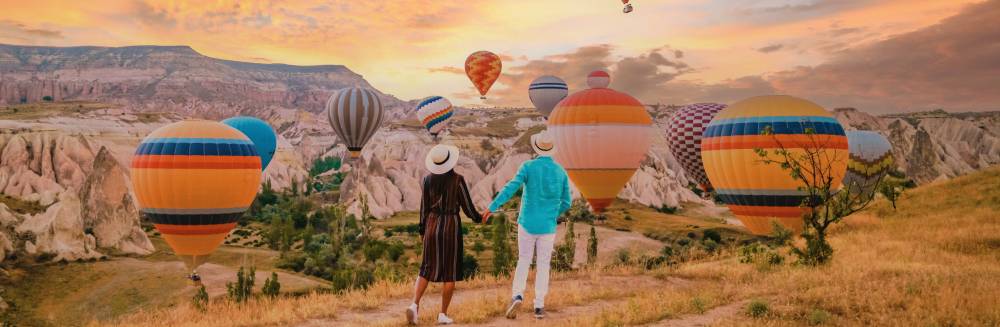 donde viajar en octubre_pareja al amanecer globos en cappadocia_turquia