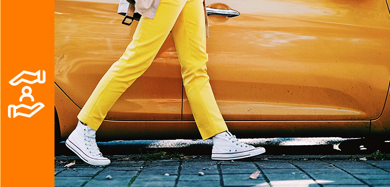 piernas y coche naranja